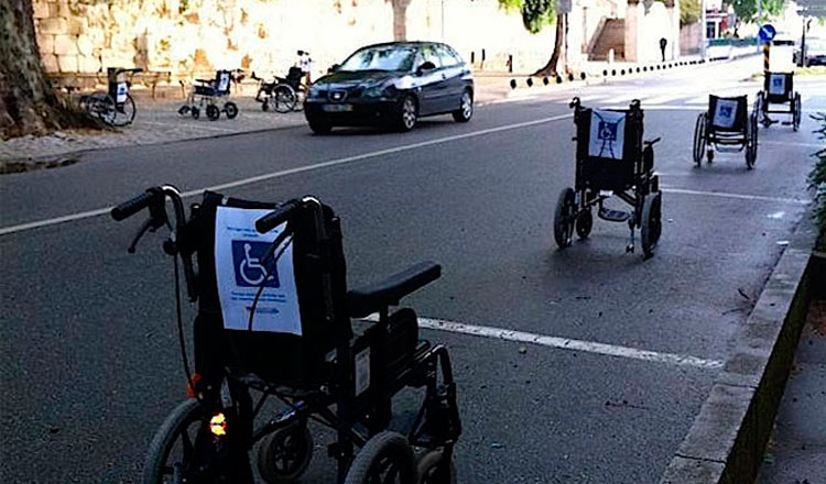 Quatro cadeiras de rodas estacionadas em uma rua