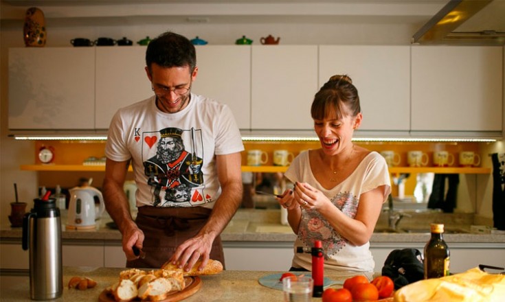 Homem e mulher na cozinha, preparando uma comida